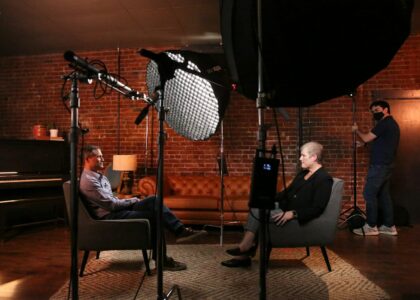 a man and a woman sitting in chairs in front of a camera